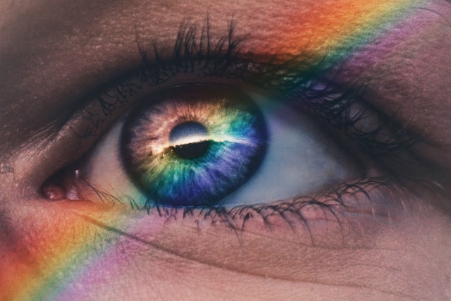 rainbow light shining on an eye with light skin